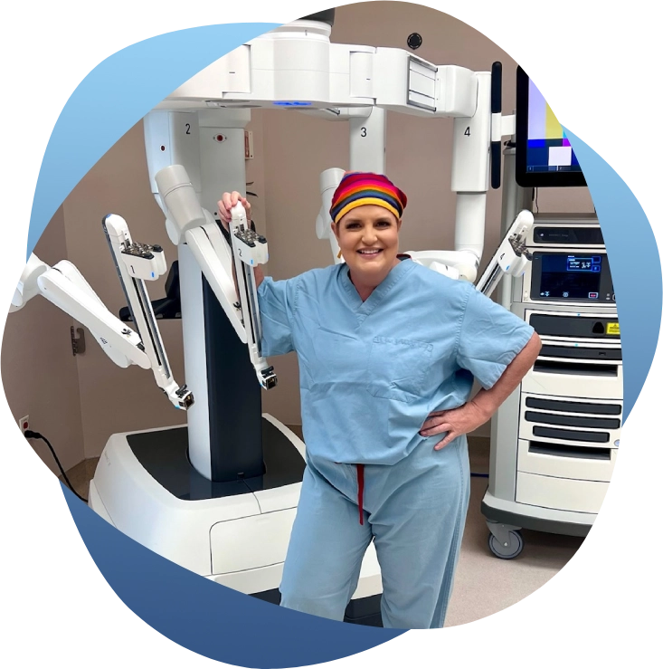 A woman in scrubs standing next to an operating room.