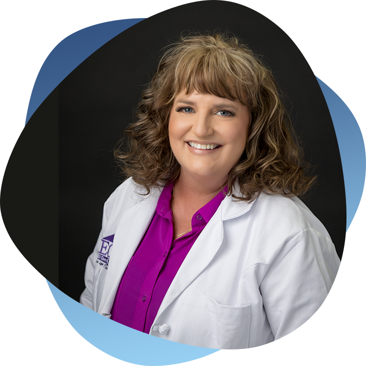 A woman in a white lab coat and purple shirt.